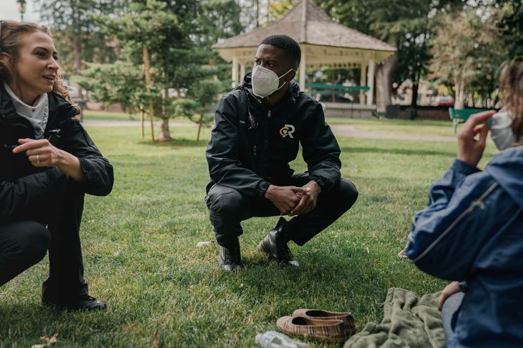 Crisis responders Aana Sundling and Chris Jones visit an unhoused community member in Olympia, Wash., to let them know about a potential shelter opportunity, in July 2020.
