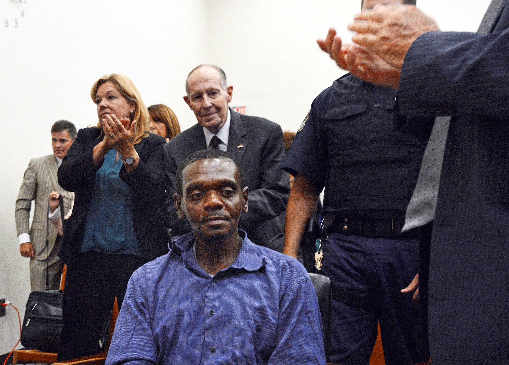 'Bev' Lake, Jr., center, stands behind Henry McCollum after a judge declared McCollum innocent of murder in September 2014. McCollum was exonerated through the innocence inquiry commission that Lake created.