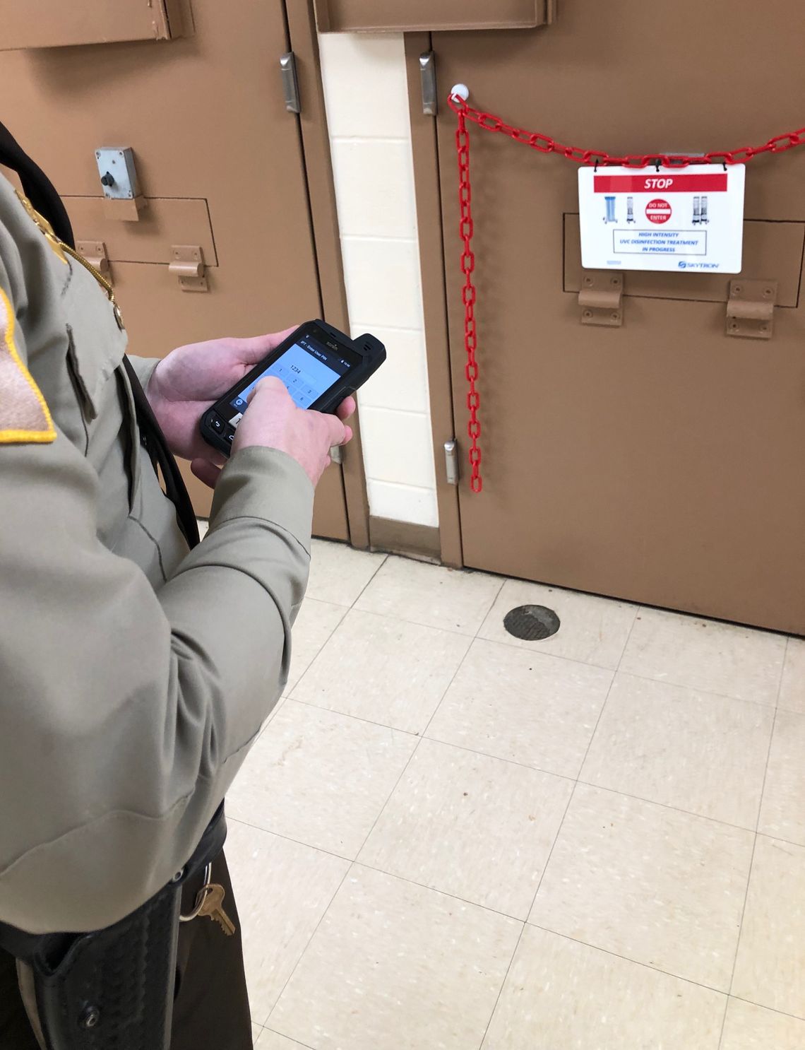 An officer at the Jefferson County Jail in Madison, Indiana, uses a handheld device to operate a machine that emits strong ultraviolet light, which is being used to disinfect the jail in the fight against coronavirus. 