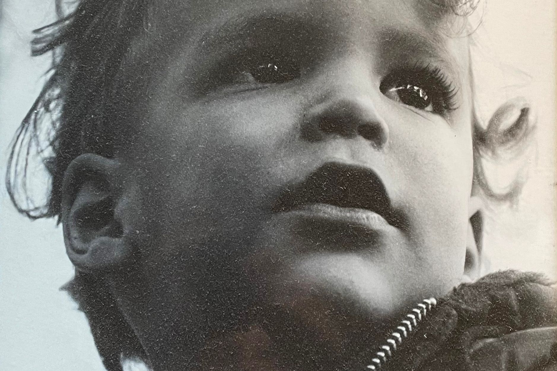 A black and white close-up portrait of a small child. 