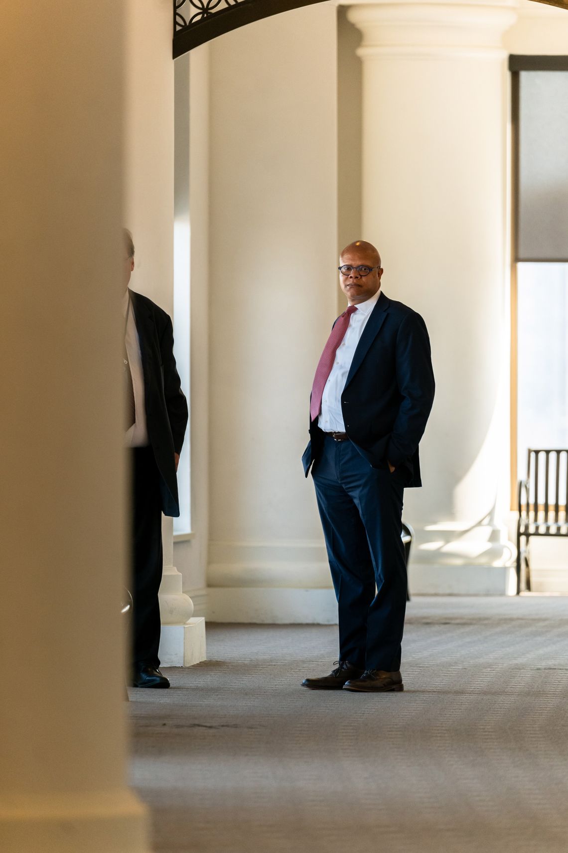 Attorney Bill Beck, a Black man wearing a dark suit and glasses, stands in the halls of the Juvenile Justice Center in Cleveland. 