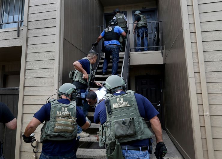 Members of the U.S. Marshals Gulf Coast Violent Offenders Task Force raid an apartment in north Houston to apprehend a murder suspect.