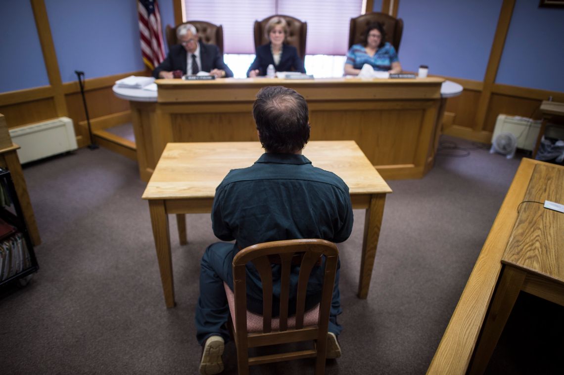 An inmate sits in handcuffs during a parol board hearing at the New Hampshire State Prison for Men in Concord, NH., on July 02, 2015.