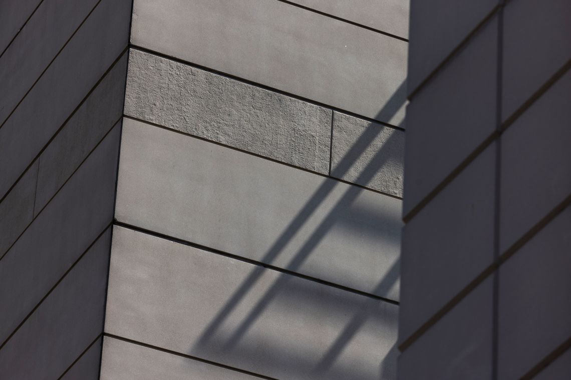 A photo shows shadows falling on the outside walls of a jail building. 