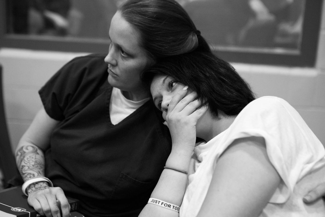 Stephanie Crowder, 25, leans on her roommate Courtnay Couch during a HARP meeting.