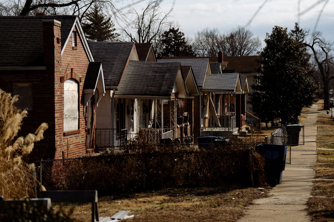 Brick houses line a road.