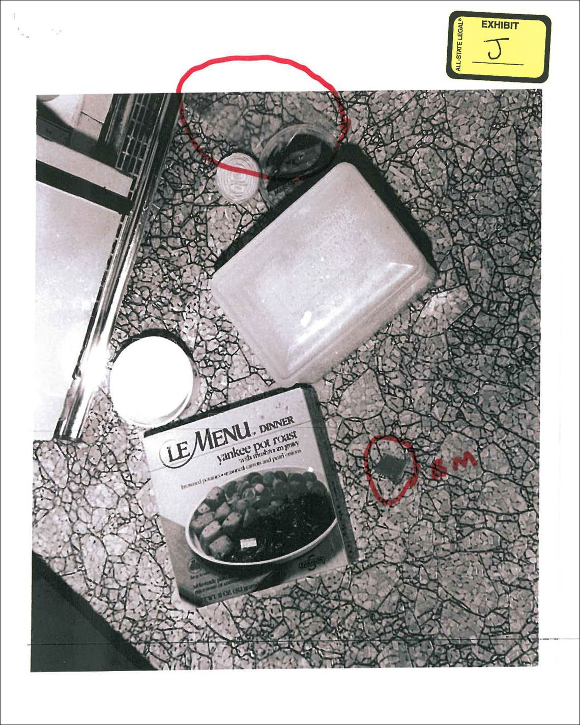 An evidence photo of the food discovered on the floor of Knoernschild’s kitchen. At top, circled in red, is the clear cheese wrapper. 
