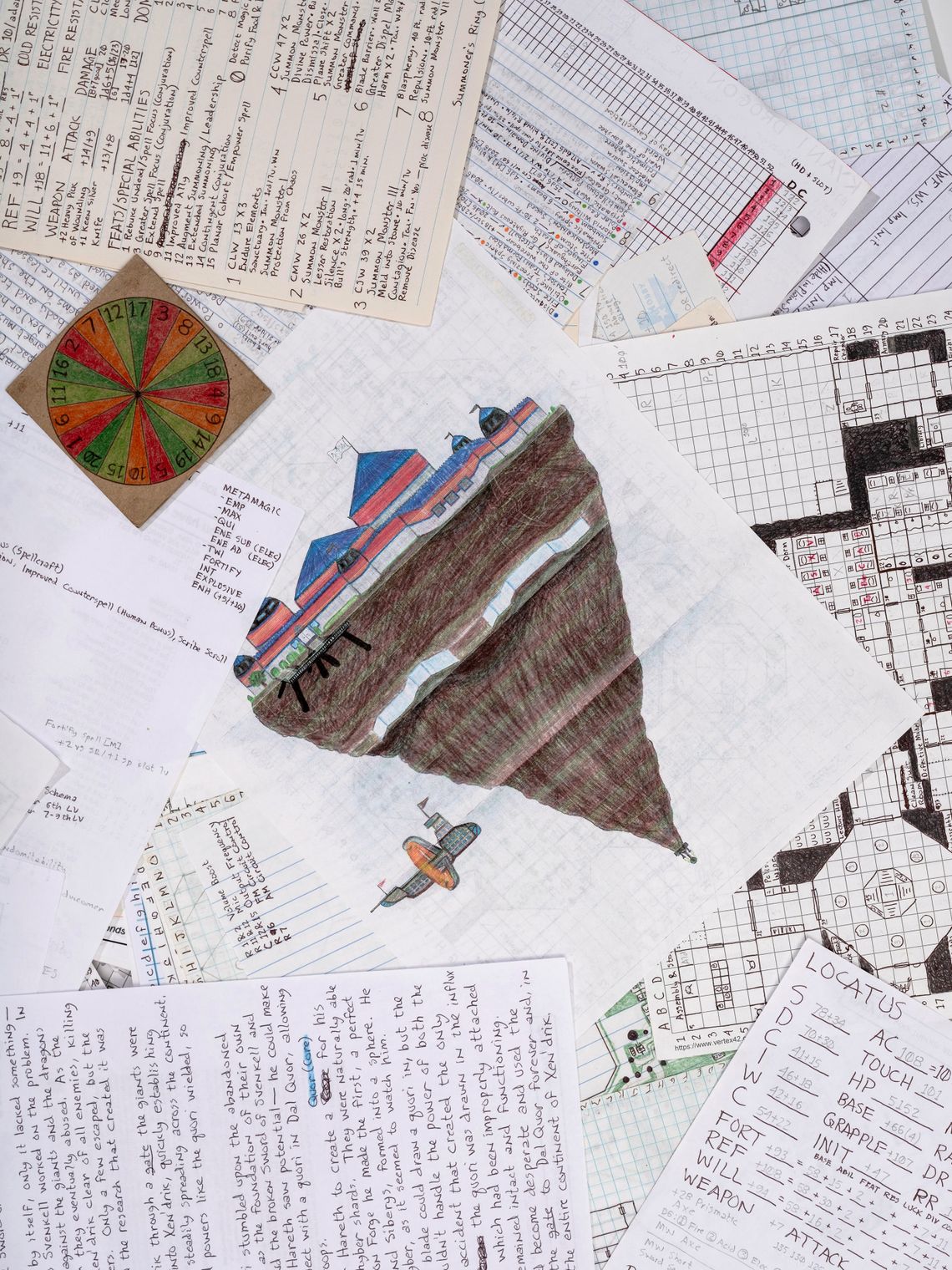 Drawings, maps and character sheets lie scattered in a pile. Atop the pile in the upper left corner sits the handmade spinner. It is a circle drawn on a square piece of board that is divided into 20 slices, each numbered and colored in alternating hues of green, orange and red. In the center of the pile of papers lies a full-page colored drawing of an upside-down mountain. On the top of the mountain, on the widest part, sits a red-and-blue striped castle. Near the bottom of the mountain, as it narrows to a point, a small submarine-style ship flies next to it, with two flags waving. An orange ring surrounds the ship vertically. 