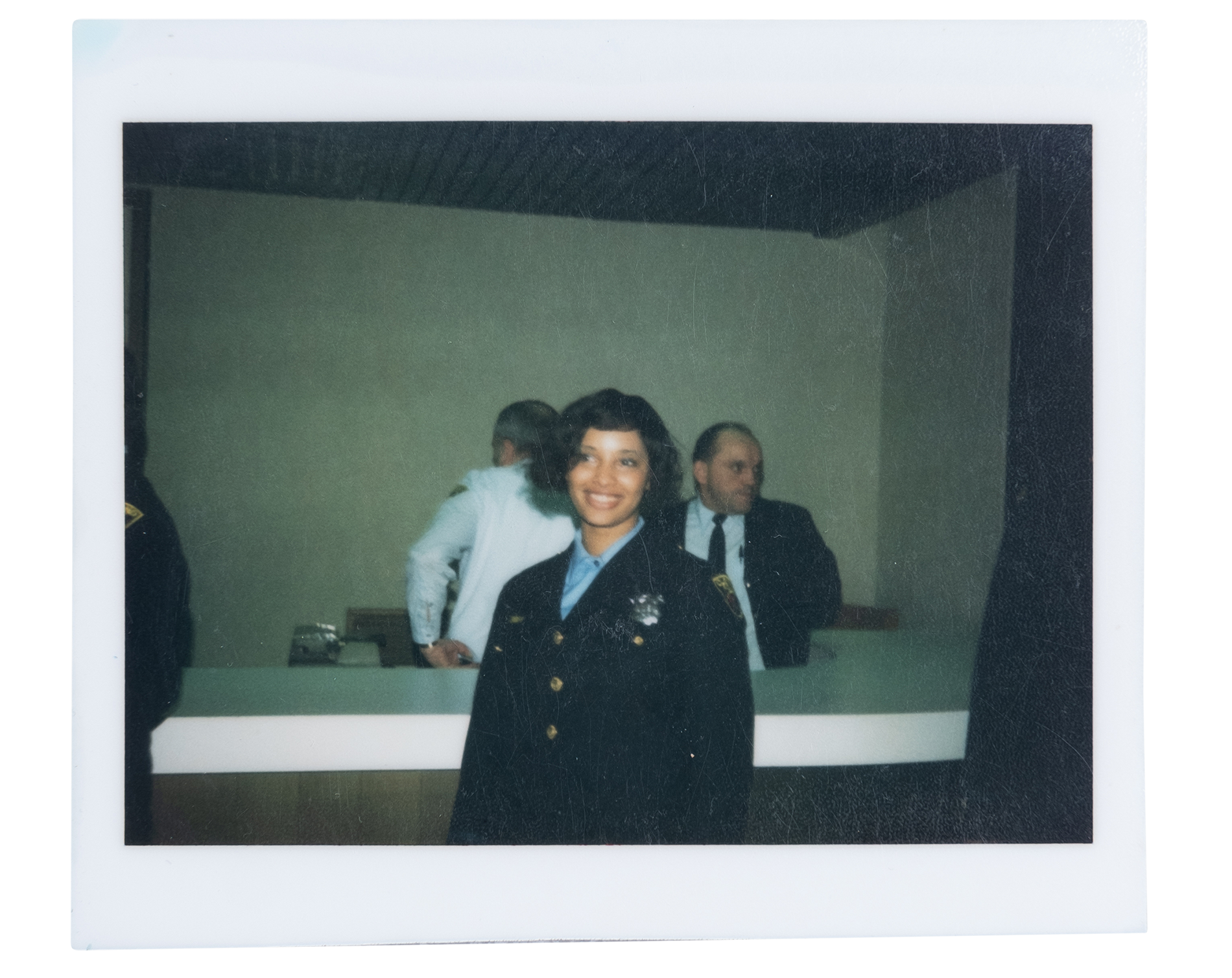 A Polaroid photo of Gayle Miller-Cooper, a Black woman, in a police uniform.