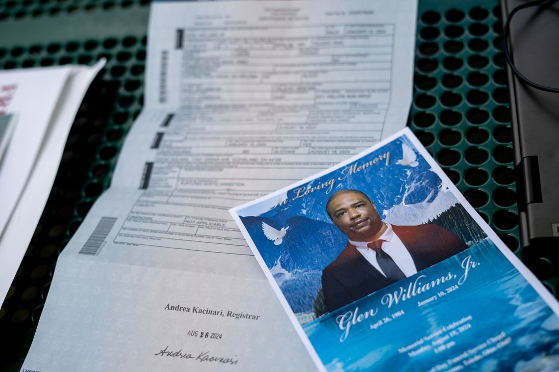 A program with a photo of Glen Williams Jr., with doves on a blue background, lies at an angle across paperwork. 