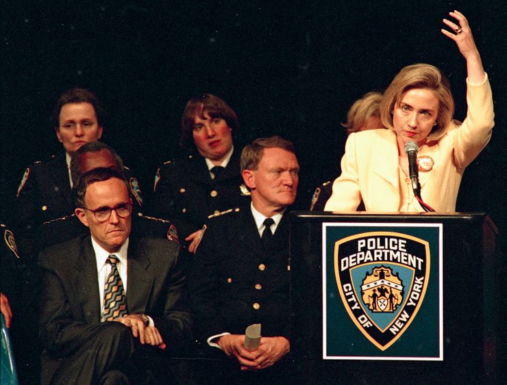 First lady Hillary Rodham Clinton makes a point during an address before the Ninth Annual Women in Policing Conference in New York, Aug. 11, 1994.  She was cheered  by policewomen after telling them, “I applaud all of you for the choices you have made.”  From left are New York City Mayor Rudy Giuliani and Police Chief John Timoney.  (AP Photo/Ed Bailey)