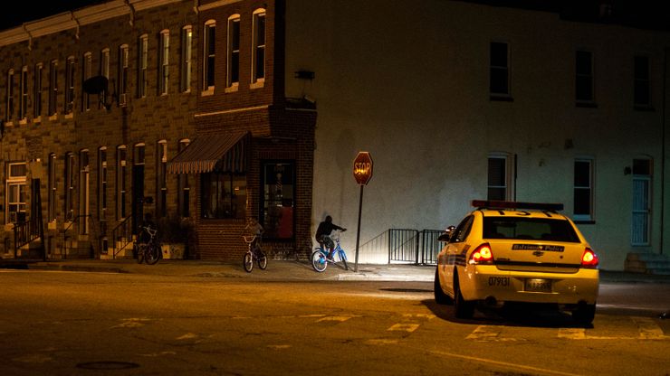 The police patrol a residential neighborhood in east Baltimore minutes after a curfew law took effect in Baltimore in August 2014.