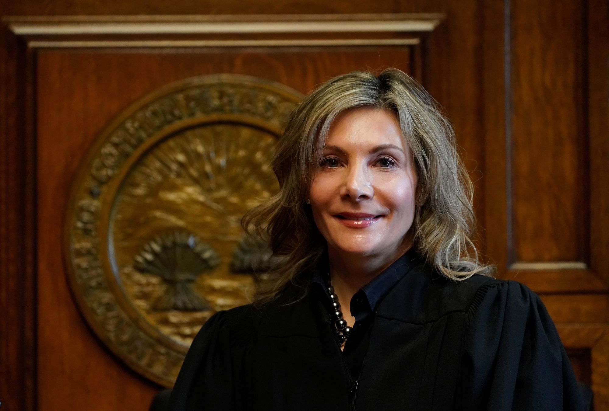 Celebrezze, a White woman with dark blonde hair, wears a black judge's robe.  