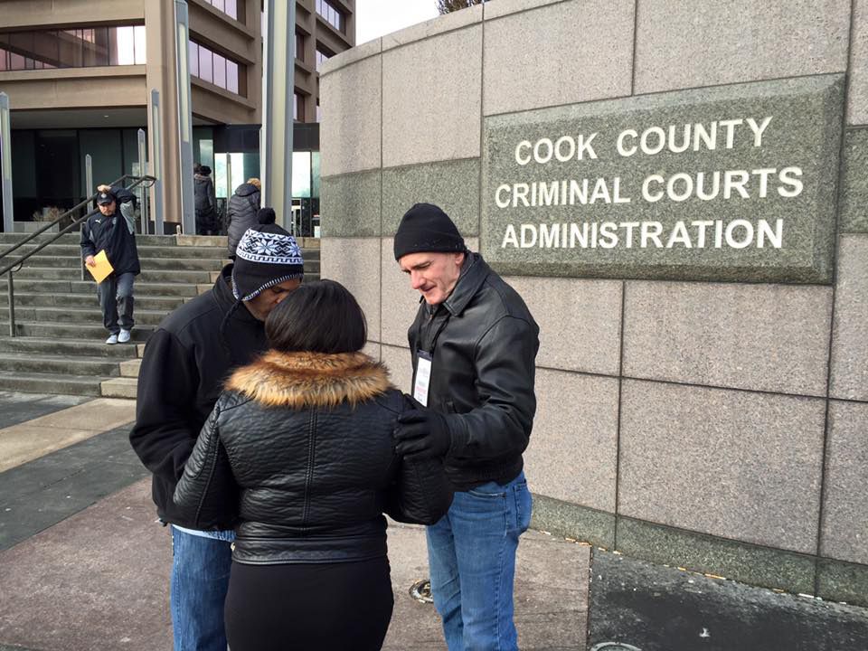 Tom Strening, the board president and chaplain for Courtside Ministries, right, leading a prayer outside the Cook County Criminal Court in 2016. 