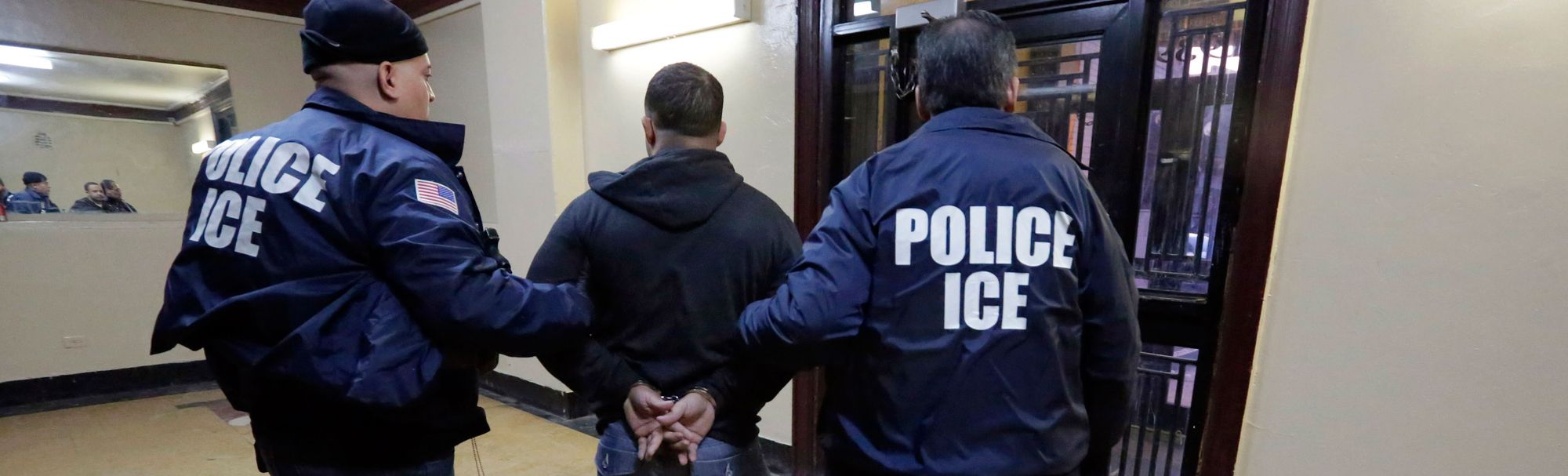 Immigration and Customs Enforcement officers escort a man out of an apartment building in the Bronx, N.Y., in 2015.