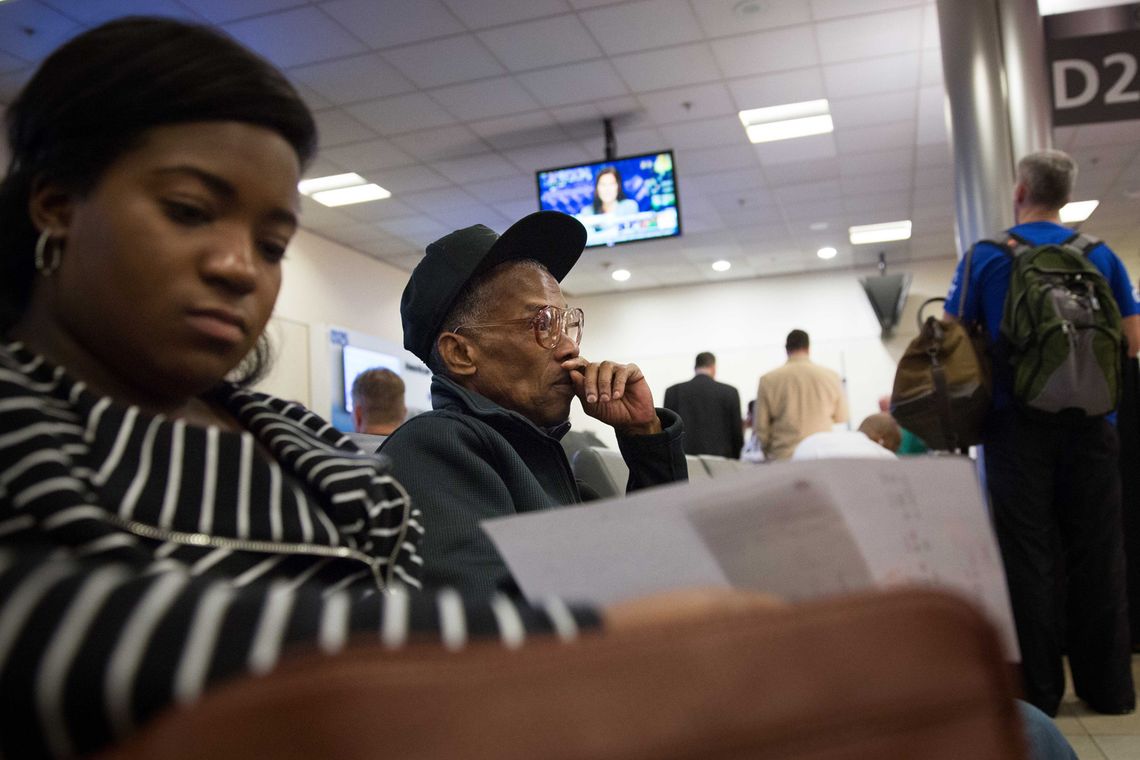 Elston sits at his gate at the Atlanta International Airport waiting for his flight to Philadelphia with his social worker. 