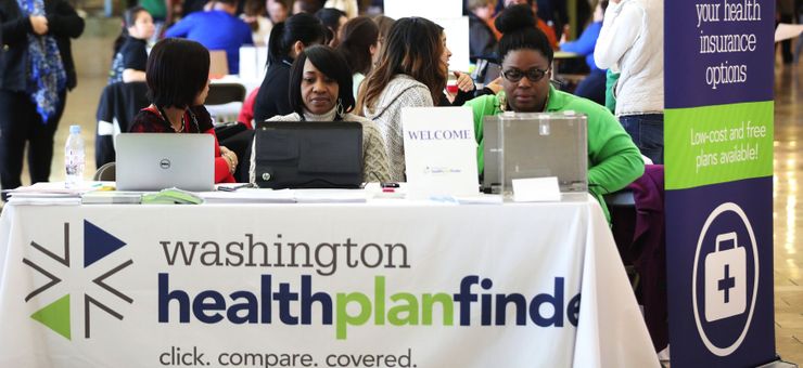 Representatives of Washington Healthplanfinder, the state’s official Affordable Care Act-compliant health benefit exchange, wait to answer questions at a sign-up event in Tukwila, Wash., in November 2014. 