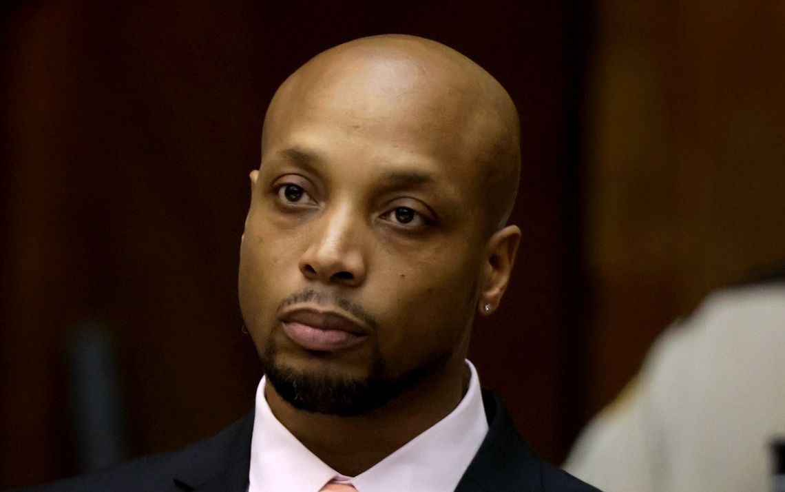 Lafeal Lawshea, a Black man wearing a black suit and pink shirt, in a courtroom.