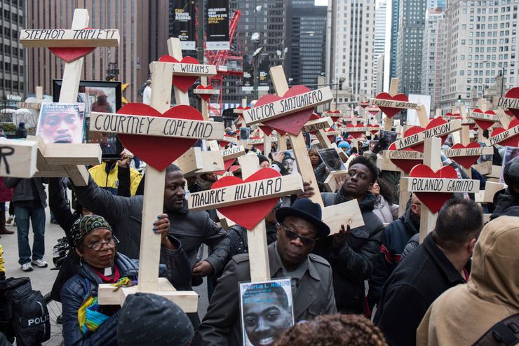 People raise wooden crosses dedicated to lives lost in Chicago, IL in 2016.