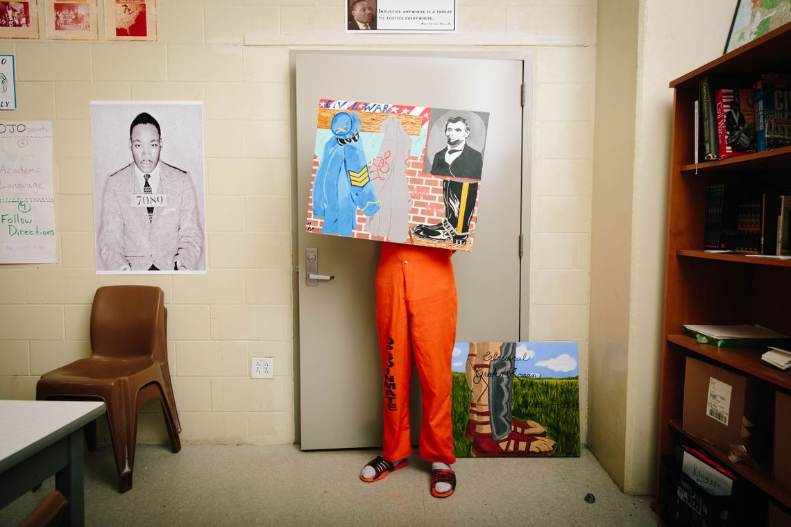 A student at the Travis Hill School inside the Orleans Justice Center displays a piece of artwork. 