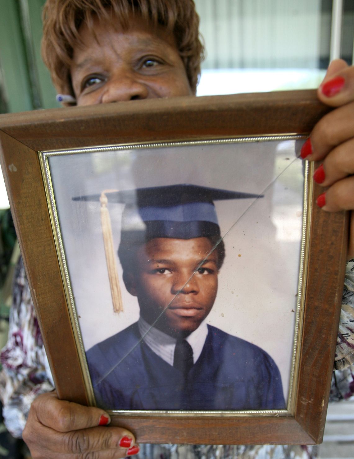 Issac’s mother holding a photo of 18-year-old Moochie.