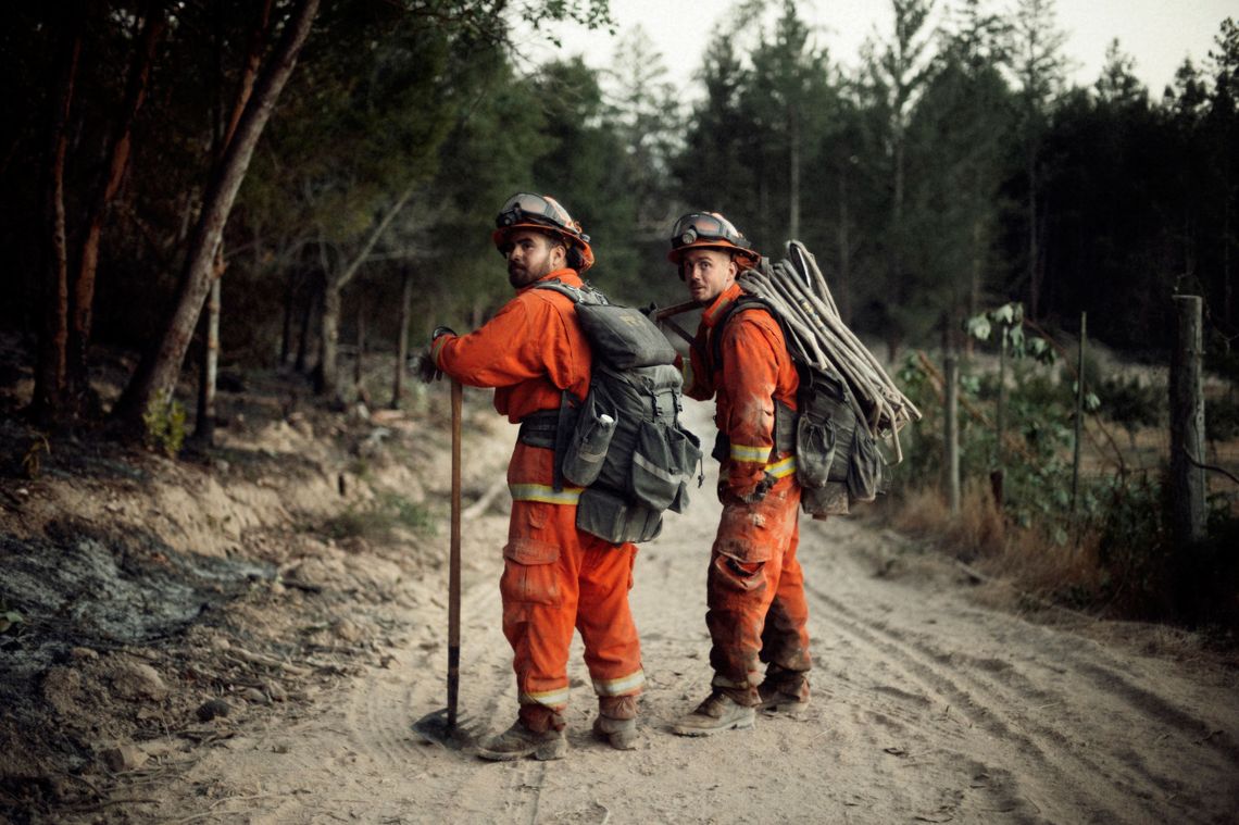 Inmate firefighters from the Antelope fire crew take a breather while carrying gear off of a burning hill during the wine country fires.