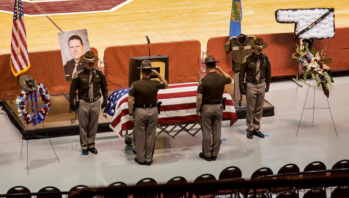 Members of the Oklahoma Highway Patrol salute the casket of Lt. Heath Meyer, who was killed when he was struck by a car driven by a fellow patrolman chasing a suspect.