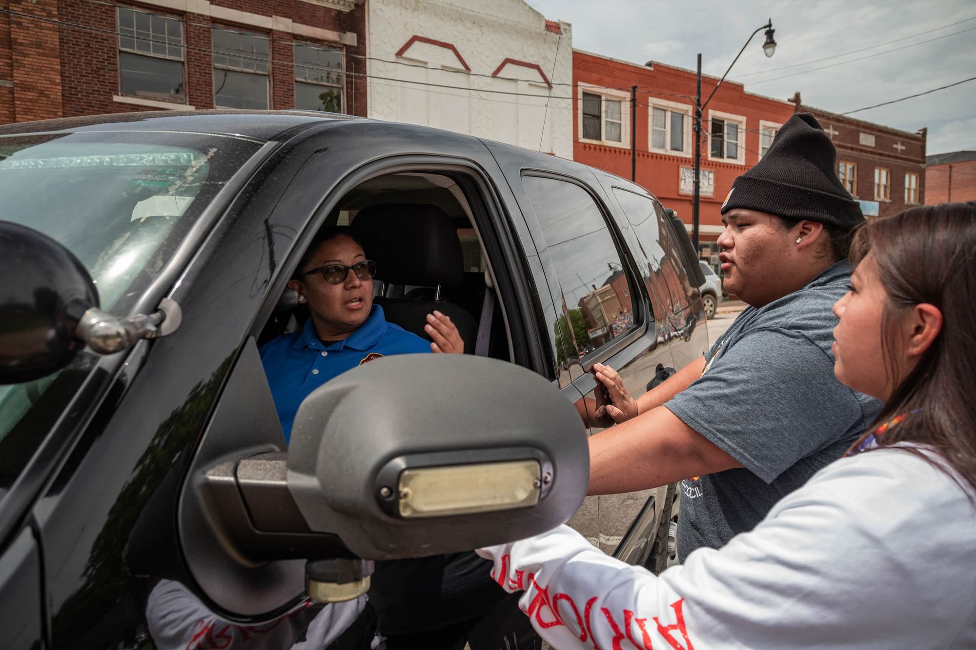 Officer Malissa Beaver of the Muscogee (Creek) Nation's Lighthorse Police Department speaks with Mikayla Buckley and Tehillah Wind in downtown Okmulgee, Oklahoma. 