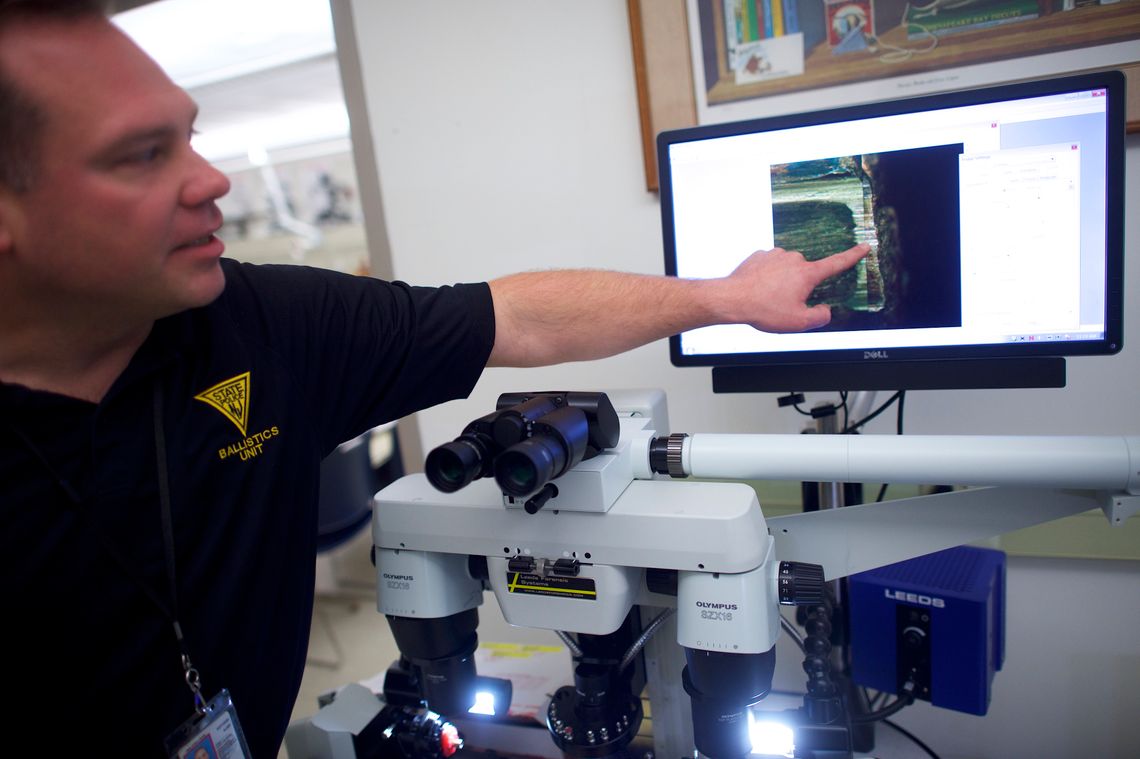 Using a microscope, New Jersey State Police Detective Edward Burek compares bullets test-fired from a gun used in a crime. The corresponding shell casings were entered into NIBIN.