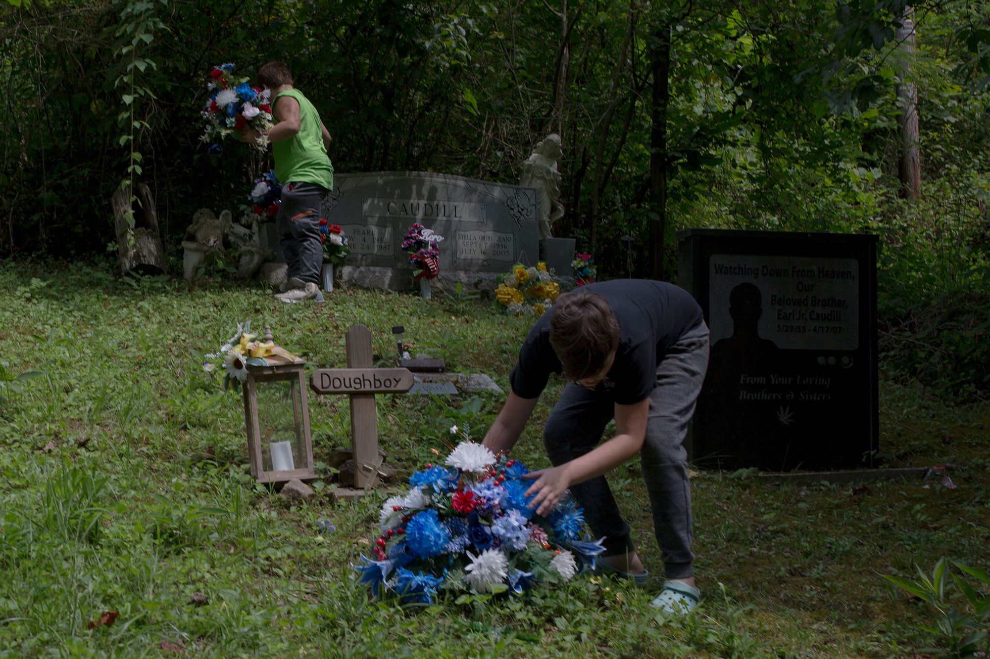 Christopher’s sons put flowers on their father’s grave. Christopher was known as “Doughboy.”