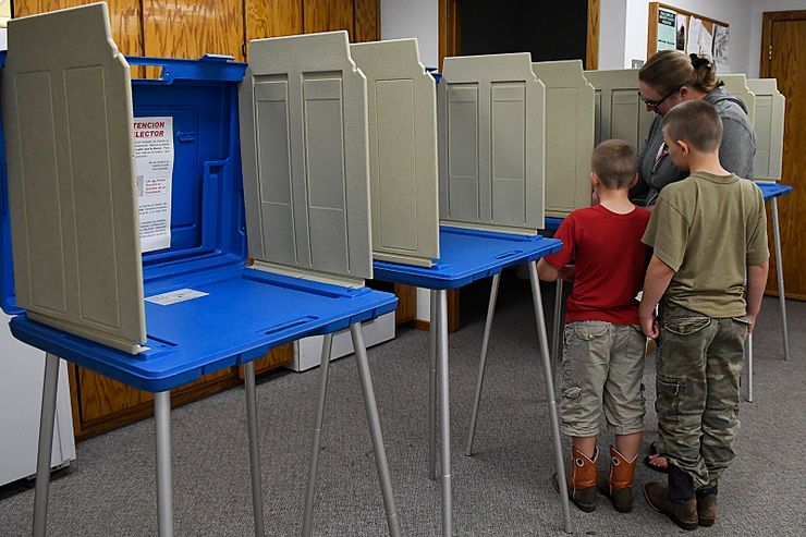 Sara Bullis fills out her election ballot with her sons, Haden and Harold, on election day in Drummond, Okla.