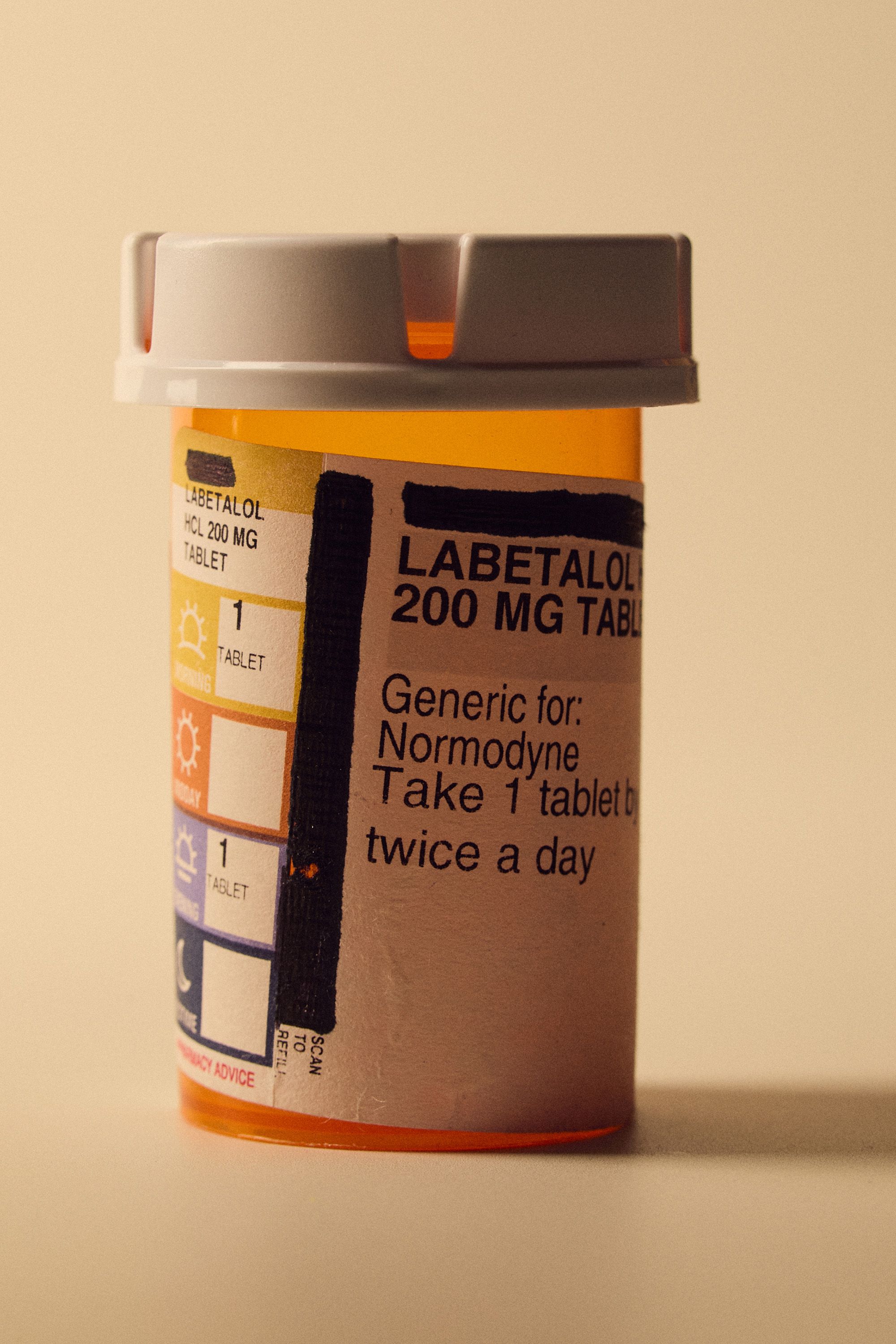 A studio shot of a orange pill bottle with the word 'labetalol' on the label.