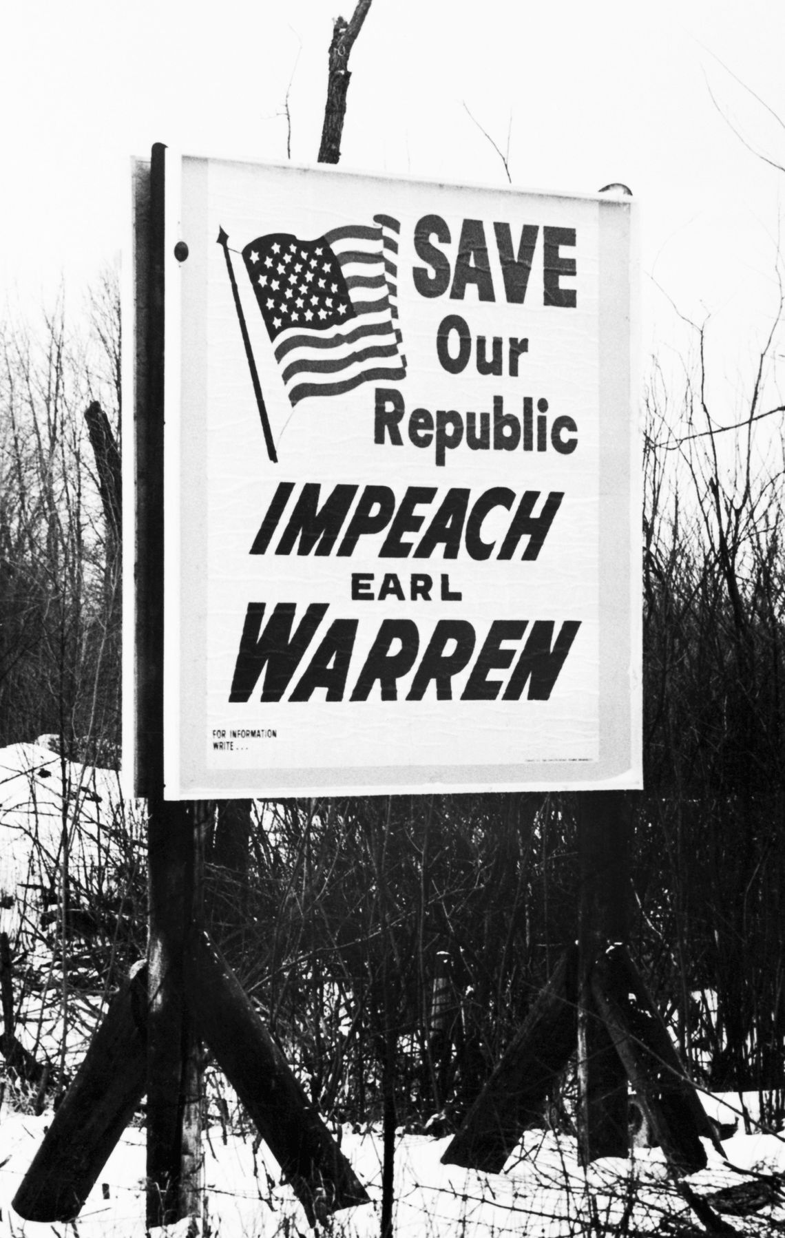 A road sign reads, “Save our republic. Impeach Earl Warren.” 