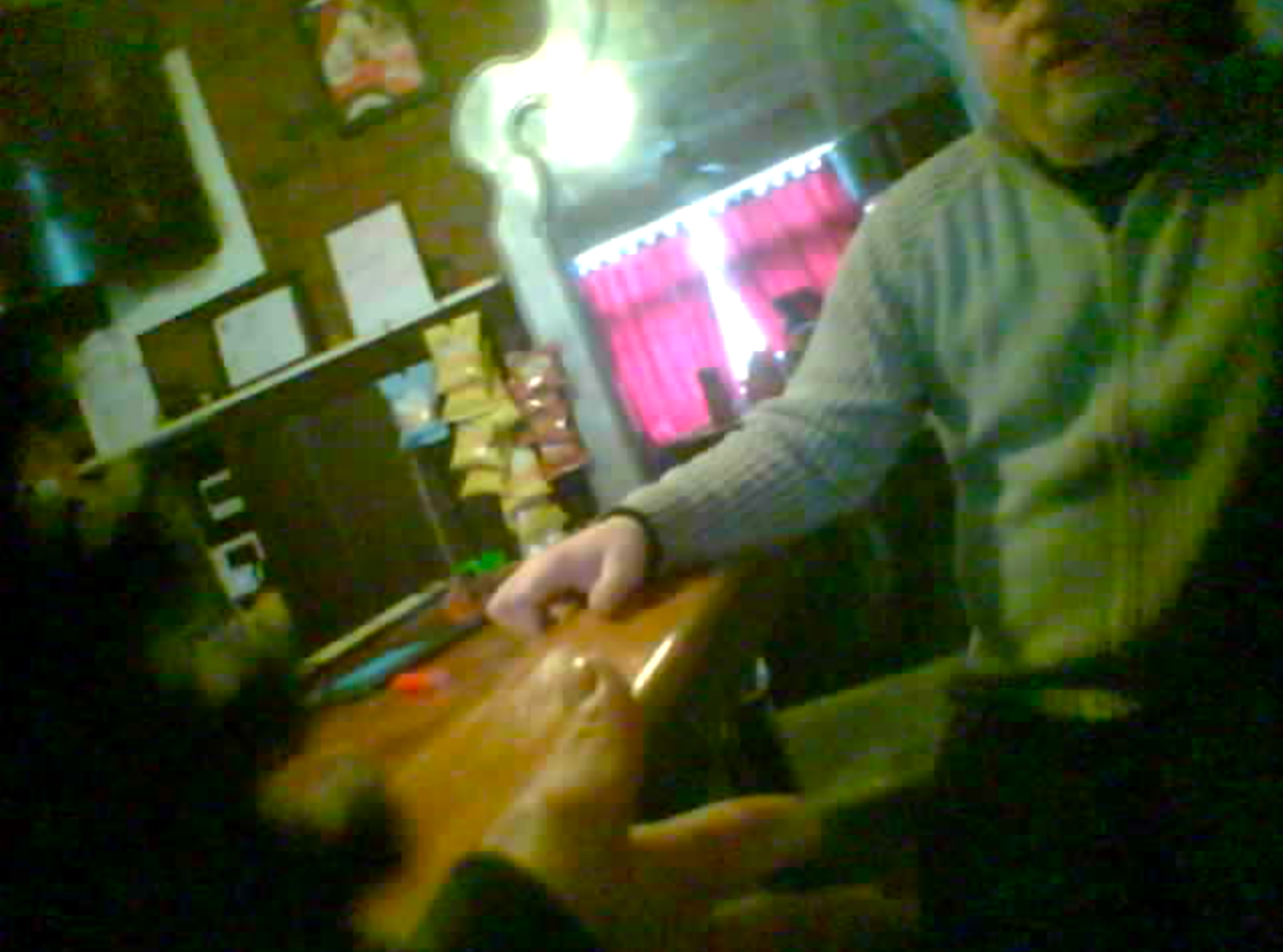 Andrew Long, a White man, wearing a baseball cap, sitting at the bar while facing in the direction of the camera. 