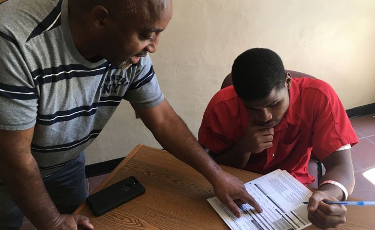 Pastor Kenneth Glasgow helps Spencer Trawick, an inmate at the Dothan City Jail in Dothan, Ala., fill out a voter registration form in June 2017.