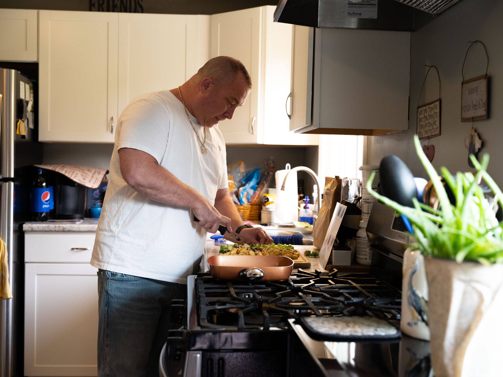 Chad Marks prepared dinner in his kitchen, in Rochester, N.Y., in September. 